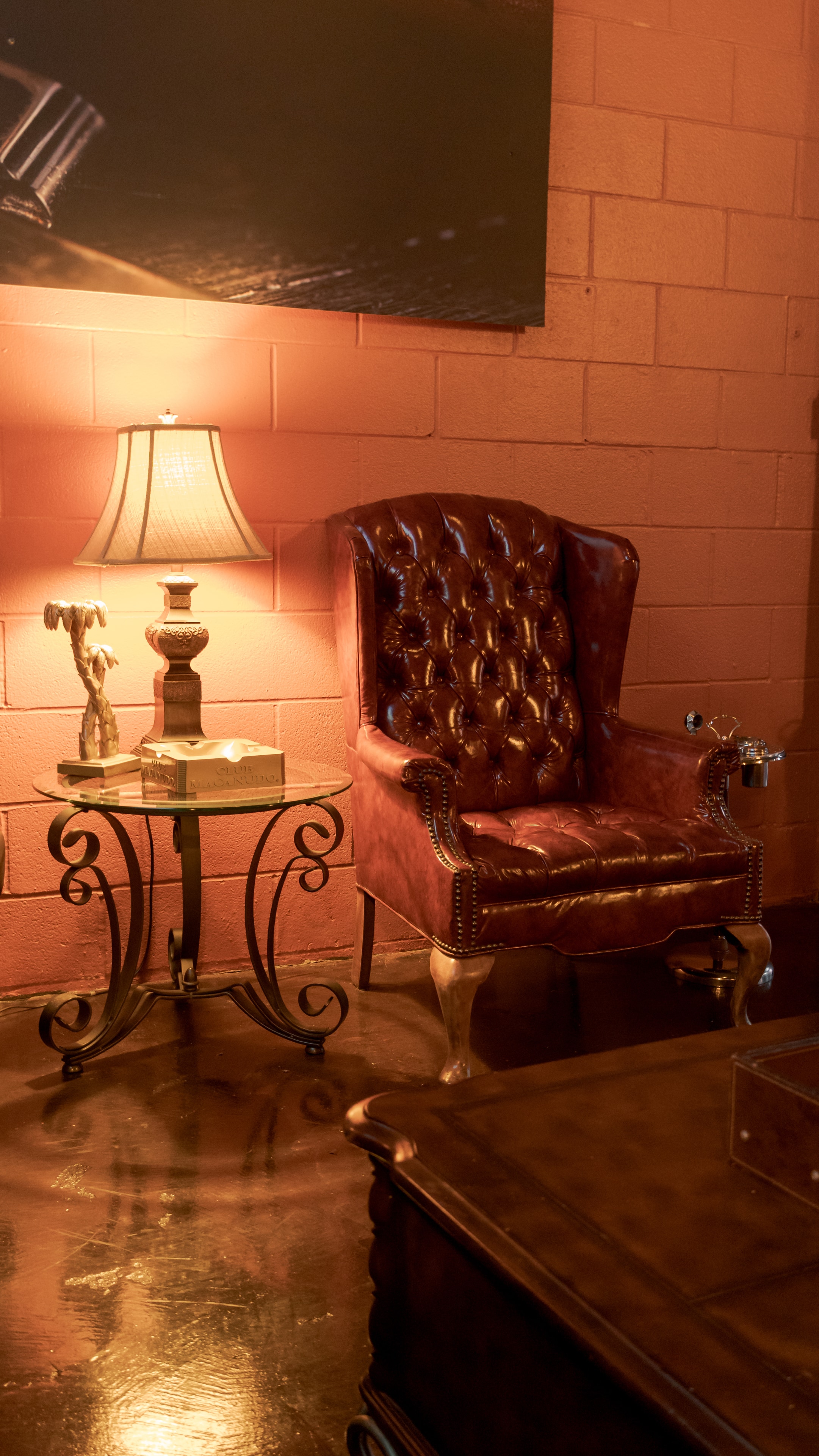 A tufted leather chair and lamp in a warmly lit corner of The Bay